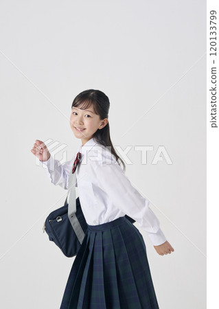 White background, Japanese female junior high school student walking with her school bag 120133799