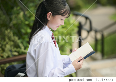 A female junior high school student reading a book in the park A female junior high school student reading a book in the park 120133824