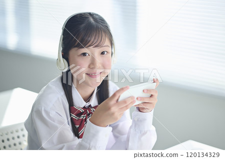 Female junior high school student taking a class on a smartphone 120134329