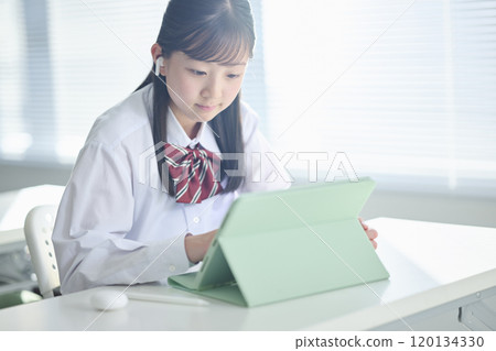 Female junior high school student taking a class on a tablet device 120134330