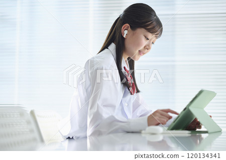 Female junior high school student taking a class on a tablet device 120134341
