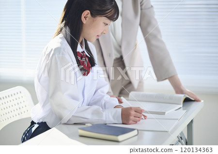 國中女生正在接受補習班老師的輔導 國中女生正在接受補習班老師的輔導 120134363