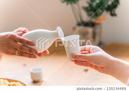 喝清酒、冷清酒和熱清酒的女人的手 喝清酒、冷清酒和熱清酒的女人的手 120134489
