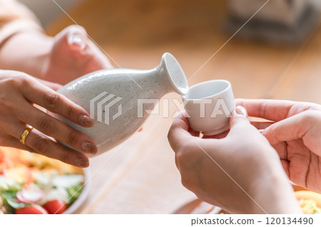 喝清酒、冷清酒和熱清酒的女人的手 喝清酒、冷清酒和熱清酒的女人的手 120134490