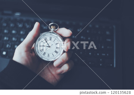 拿著懷錶和打開的筆記型電腦的人的手 120135628