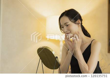晚上客廳裡一位年輕女性的皮膚護理 晚上客廳裡一位年輕女性的皮膚護理 120135731