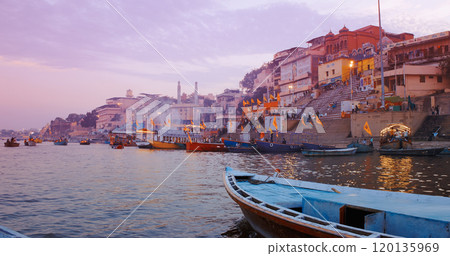 Varanasi, Uttar Pradesh, India. Many Boats moored on Ganga river near ghats. Hundreds of tourists and locals come in boats to watch Ganga Maha Aarti ceremony and the fire ceremony. Purple sunset sky 120135969