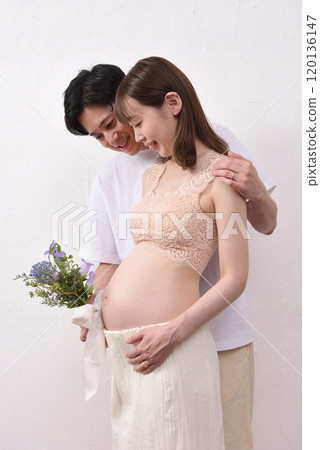 Pregnant young wife and husband holding a bouquet of flowers 120136147