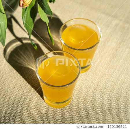 Passion fruit cold drink, welcome drinks set, yellow iced tea, fruit cocktails in small glass with ice on restaurant table Passion fruit cold drink, welcome drinks set, yellow iced tea, fruit cocktails in small glass with ice on restaurant table 120136221