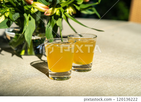 Passion fruit cold drink, welcome drinks set, yellow iced tea, fruit cocktails in small glass with ice on restaurant table Passion fruit cold drink, welcome drinks set, yellow iced tea, fruit cocktails in small glass with ice on restaurant table 120136222