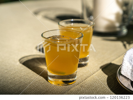 Passion fruit cold drink, welcome drinks set, yellow iced tea, fruit cocktails in small glass with ice on restaurant table Passion fruit cold drink, welcome drinks set, yellow iced tea, fruit cocktails in small glass with ice on restaurant table 120136223