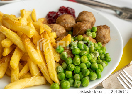 Meatballs with french fries, green peas, bechamel sauce and cranberry jam, meat balls on white plate Meatballs with french fries, green peas, bechamel sauce and cranberry jam, meat balls on white plate 120136942