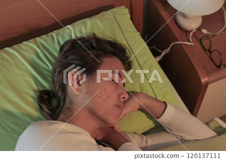 Peaceful night rest - woman sleeping comfortably in bed. Peaceful night rest - woman sleeping comfortably in bed. 120137111