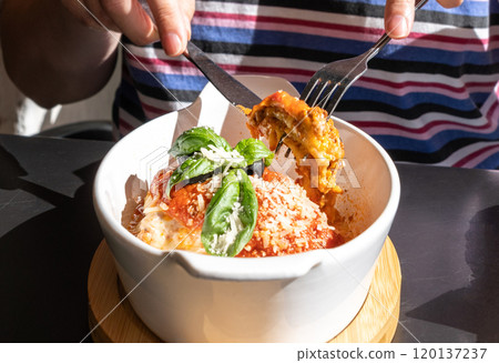 Lasagna portion, oven baked lasagne, pasta layers with cheese, minced meat, tomato in sunny summer day Lasagna portion, oven baked lasagne, pasta layers with cheese, minced meat, tomato in sunny summer day 120137237