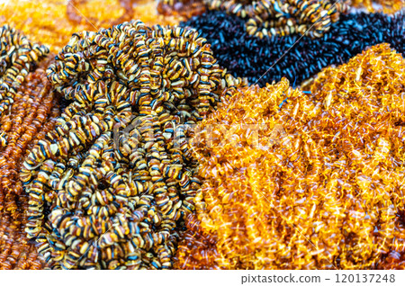 Amber stones market, polished orange gemstones closeup, natural Baltic amber gems jewelry store 120137248