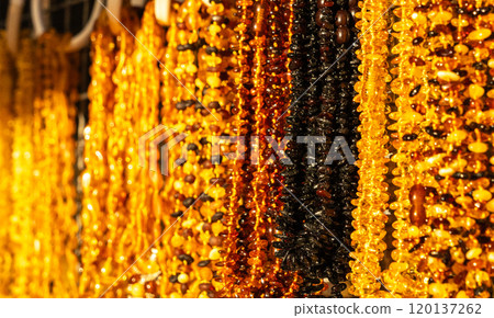 Amber stones market, polished orange gemstones closeup, natural Baltic amber gems jewelry store 120137262