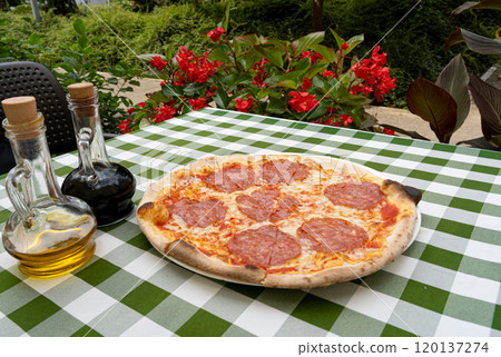 Pepperoni Pizza on Restaurant Plate, Salami Pizza with Olives, Tomatoes and Mozzarella Cheese 120137274