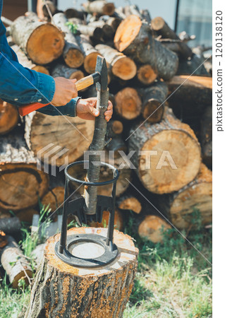 Place the firewood on the chopping block and hit it with a hammer Place the firewood on the chopping block and hit it with a hammer 120138120