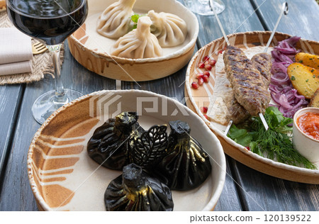 Black khinkali, Georgian seafood chinkali, spicy dumplings with minced meat also called dimsum Black khinkali, Georgian seafood chinkali, spicy dumplings with minced meat also called dimsum 120139522