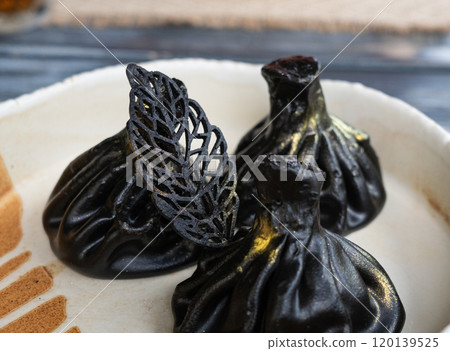 Black khinkali, Georgian seafood chinkali, spicy dumplings with minced meat also called dimsum 120139525