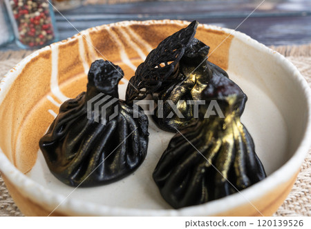 Black khinkali, Georgian seafood chinkali, spicy dumplings with minced meat also called dimsum 120139526