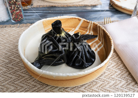Black khinkali, Georgian seafood chinkali, spicy dumplings with minced meat also called dimsum Black khinkali, Georgian seafood chinkali, spicy dumplings with minced meat also called dimsum 120139527