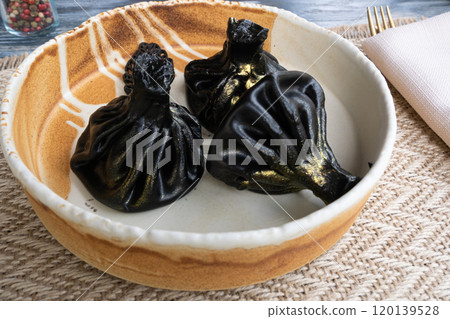 Black khinkali, Georgian seafood chinkali, spicy dumplings with minced meat also called dimsum Black khinkali, Georgian seafood chinkali, spicy dumplings with minced meat also called dimsum 120139528