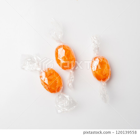 Orange hard candies isolated. Scattered lollipop pile, wrappers fruit confectionery group, round sweets Orange hard candies isolated. Scattered lollipop pile, wrappers fruit confectionery group, round sweets 120139558