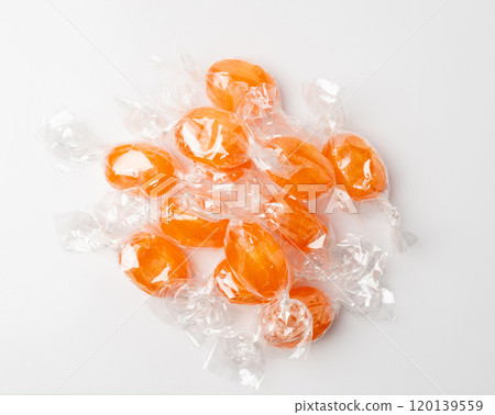 Orange hard candies isolated. Scattered lollipop pile, wrappers fruit confectionery group, round sweets Orange hard candies isolated. Scattered lollipop pile, wrappers fruit confectionery group, round sweets 120139559