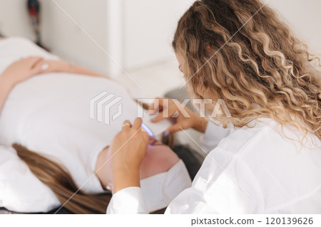 Professional female cosmetologist doing procedure in Cosmetology clinic. Rejuvenation and Hydratation. Professional female cosmetologist doing procedure in Cosmetology clinic. Rejuvenation and Hydratation. 120139626