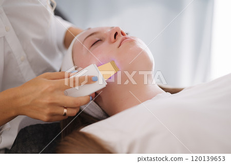 Female at cosmetic beauty spa clinic has facial hardware cosmetology. Woman making beauty procedures Female at cosmetic beauty spa clinic has facial hardware cosmetology. Woman making beauty procedures 120139653