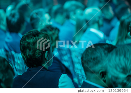 Focused audience at a business conference in blue lighting Focused audience at a business conference in blue lighting 120139964