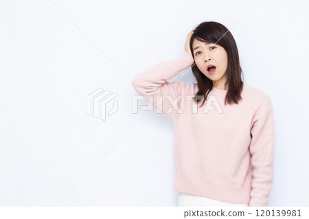 A woman holding her head and turning pale A woman holding her head and turning pale 120139981