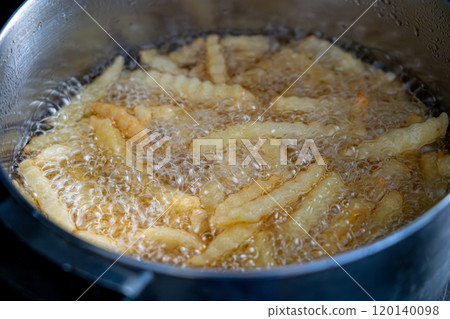 Potatoes in boiling oil, homemade french fries, deep fried potato cooking in metal fryer pot, fat fast food Potatoes in boiling oil, homemade french fries, deep fried potato cooking in metal fryer pot, fat fast food 120140098