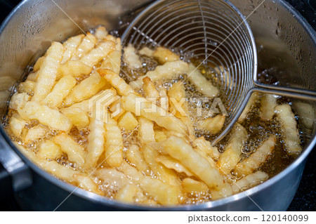 Potatoes in boiling oil, homemade french fries, deep fried potato cooking in metal fryer pot, fat fast food Potatoes in boiling oil, homemade french fries, deep fried potato cooking in metal fryer pot, fat fast food 120140099