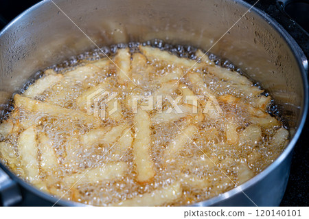 Potatoes in boiling oil, homemade french fries, deep fried potato cooking in metal fryer pot, fat fast food 120140101
