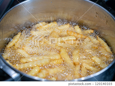 Potatoes in boiling oil, homemade french fries, deep fried potato cooking in metal fryer pot, fat fast food Potatoes in boiling oil, homemade french fries, deep fried potato cooking in metal fryer pot, fat fast food 120140103