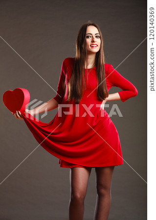 Woman red dress holds heart shaped box Woman red dress holds heart shaped box 120140369