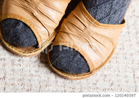 Woman feet with socks in slippers at home 120140397
