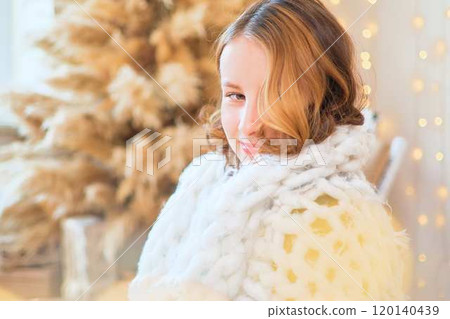 teenage girl in a dress near an unconventional Christmas tree surrounded by golden lights teenage girl in a dress near an unconventional Christmas tree surrounded by golden lights 120140439