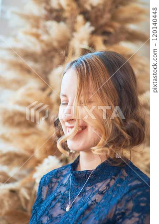 teenage girl in a dress near an unconventional Christmas tree surrounded by golden lights teenage girl in a dress near an unconventional Christmas tree surrounded by golden lights 120140448
