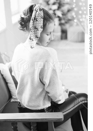 fragile teenage girl surrounded by Christmas lights 120140549