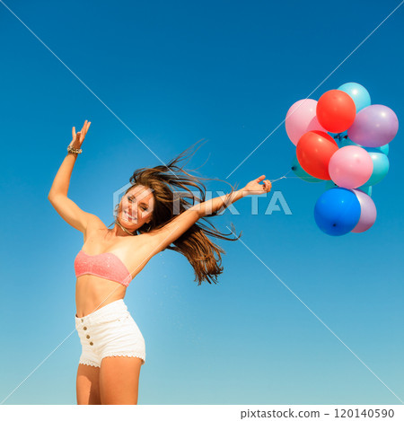 Girl jumping with colorful balloons on sky background 120140590