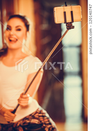 Happy cute girl taking photo with selfie stick. 120140747