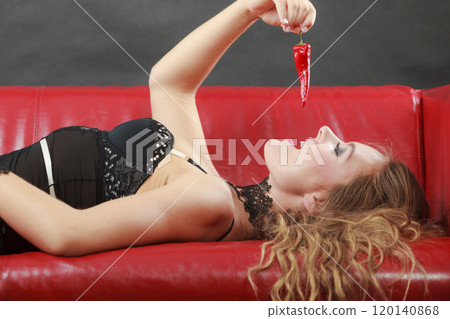Woman wearing lingerie holding chilli pepper Woman wearing lingerie holding chilli pepper 120140868