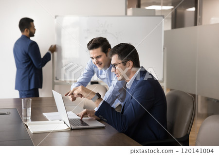 Two diverse business coworker men watching Internet project presentation 120141004
