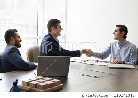 Team of cheerful businessmen shaking hands after negotiation 120141015