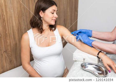 Doctor Administering Vaccine to Calm Pregnant Woman in Clinic 120141034
