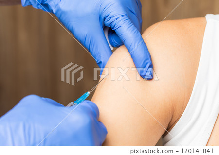 Nurse administering vaccination injection close-up 120141041
