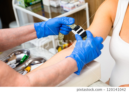 Nurse preparing patients arm for taking blood sample 120141042
